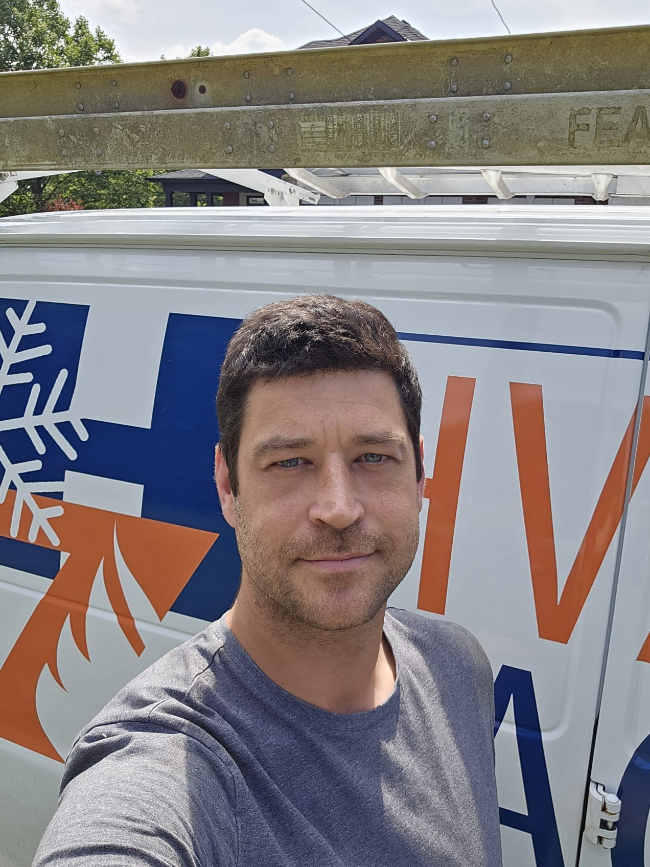 HVAC Zack standing in front of his service van, ready to help Durham Region homeowners with heating and cooling needs.