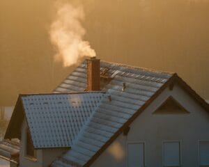 Snow-covered Durham Region home with smoke rising from the chimney on a winter morning — representing home heating systems.