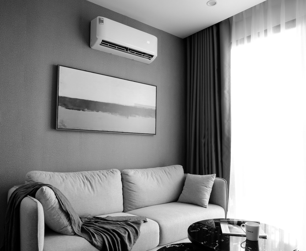 Wall mounted mini split head with outdoor unit on a raised stand at a Durham Region home.