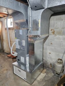 New central air handler and duct transitions installed where an old oil furnace stood in a Colborne basement.