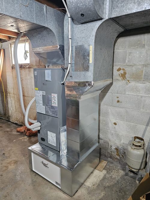 New central air handler and duct transitions installed where an old oil furnace stood in a Colborne basement.